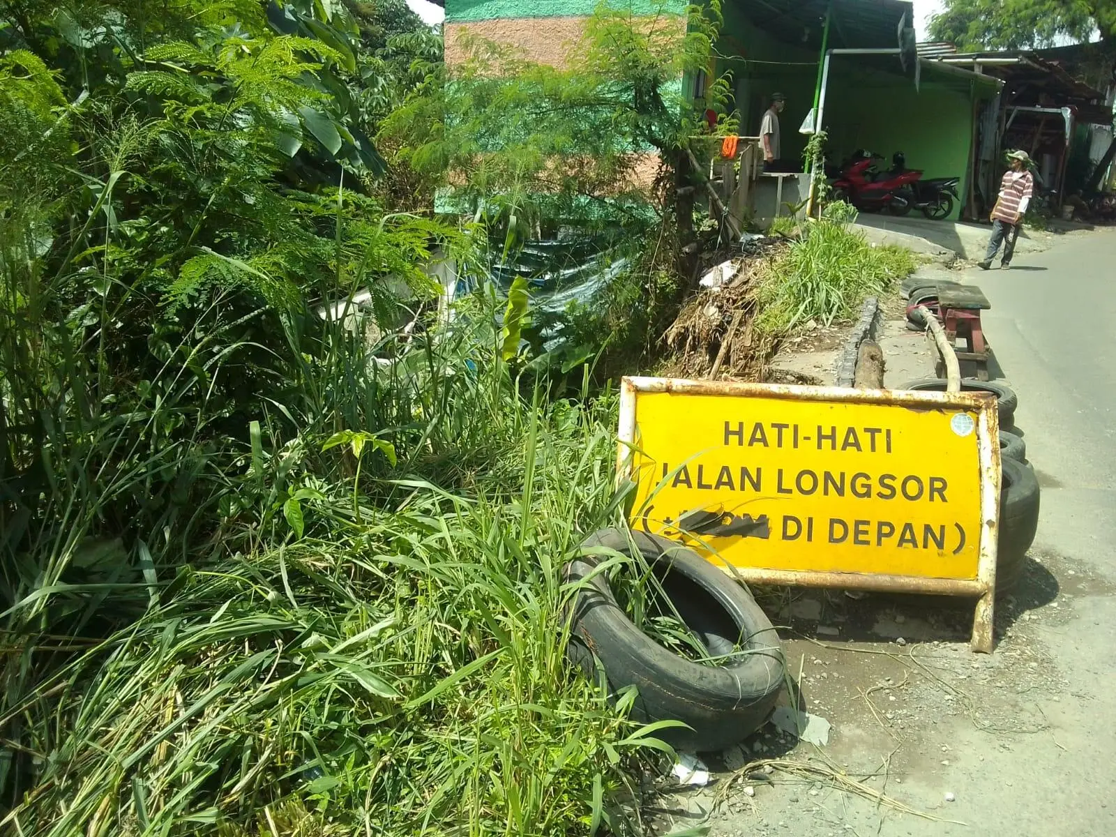 Warga Katulampa Gunakan Ban Bekas untuk Pembatas Jalan Longsor